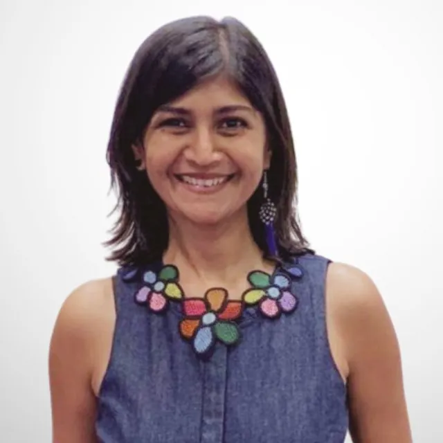 Portrait of Gauri Sharma, Head of Data and Analytics at BevGenie, wearing a denim top and a colourful beaded necklace.