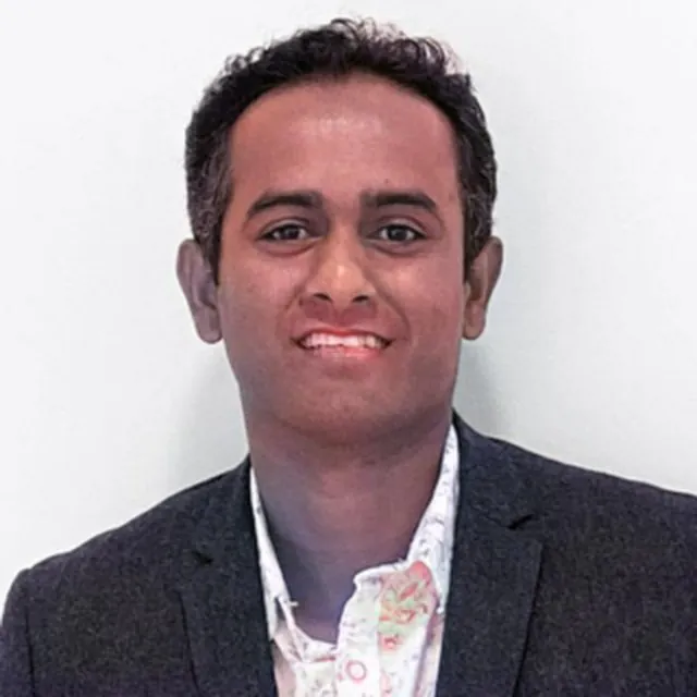 Portrait of Shyam Jayakumar, Founder and CEO of BevGenie, wearing a dark blazer over a patterned shirt.
